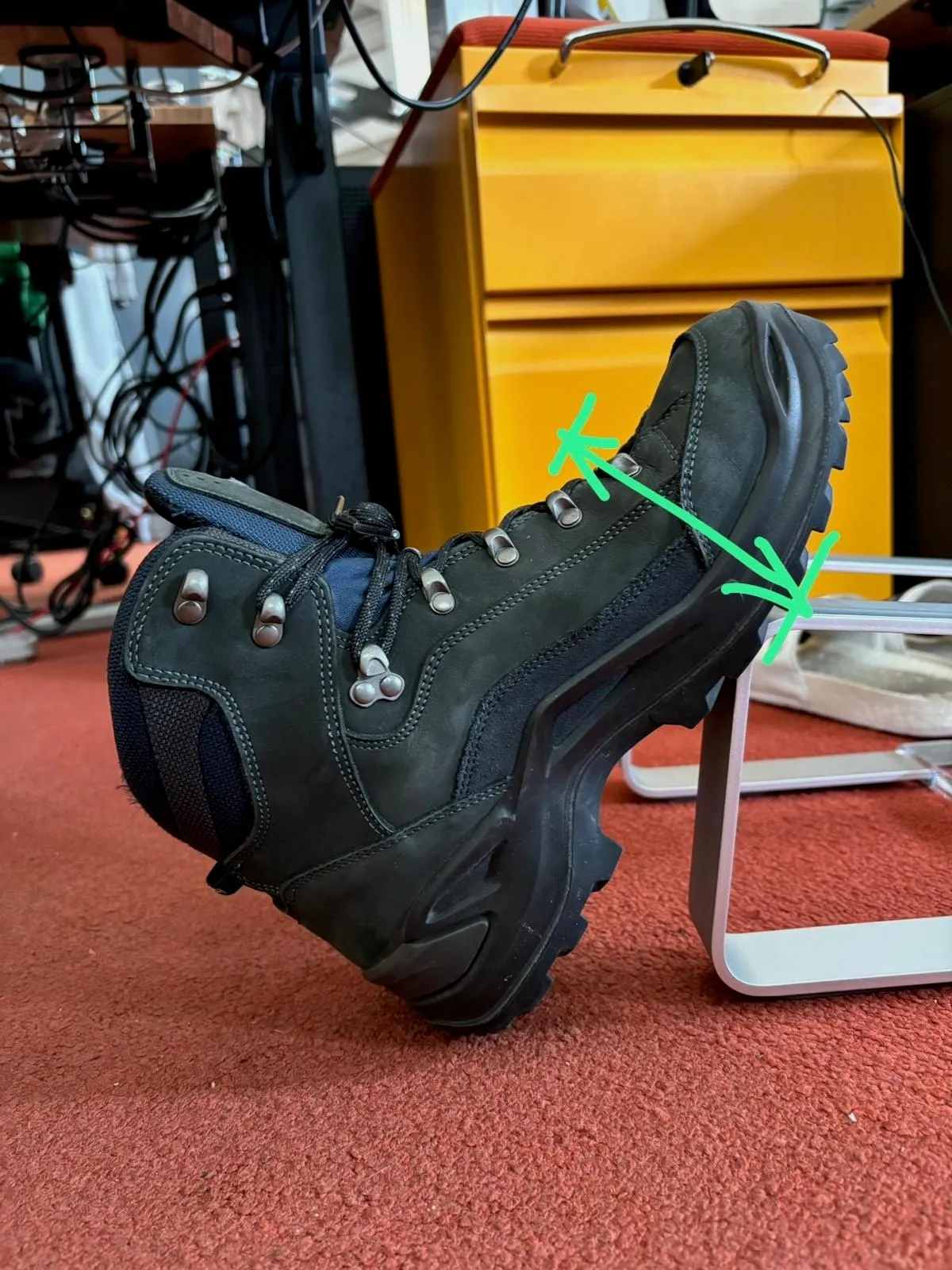A picture of a boot positioned at an angle with an arrow marking the height of the toe box.