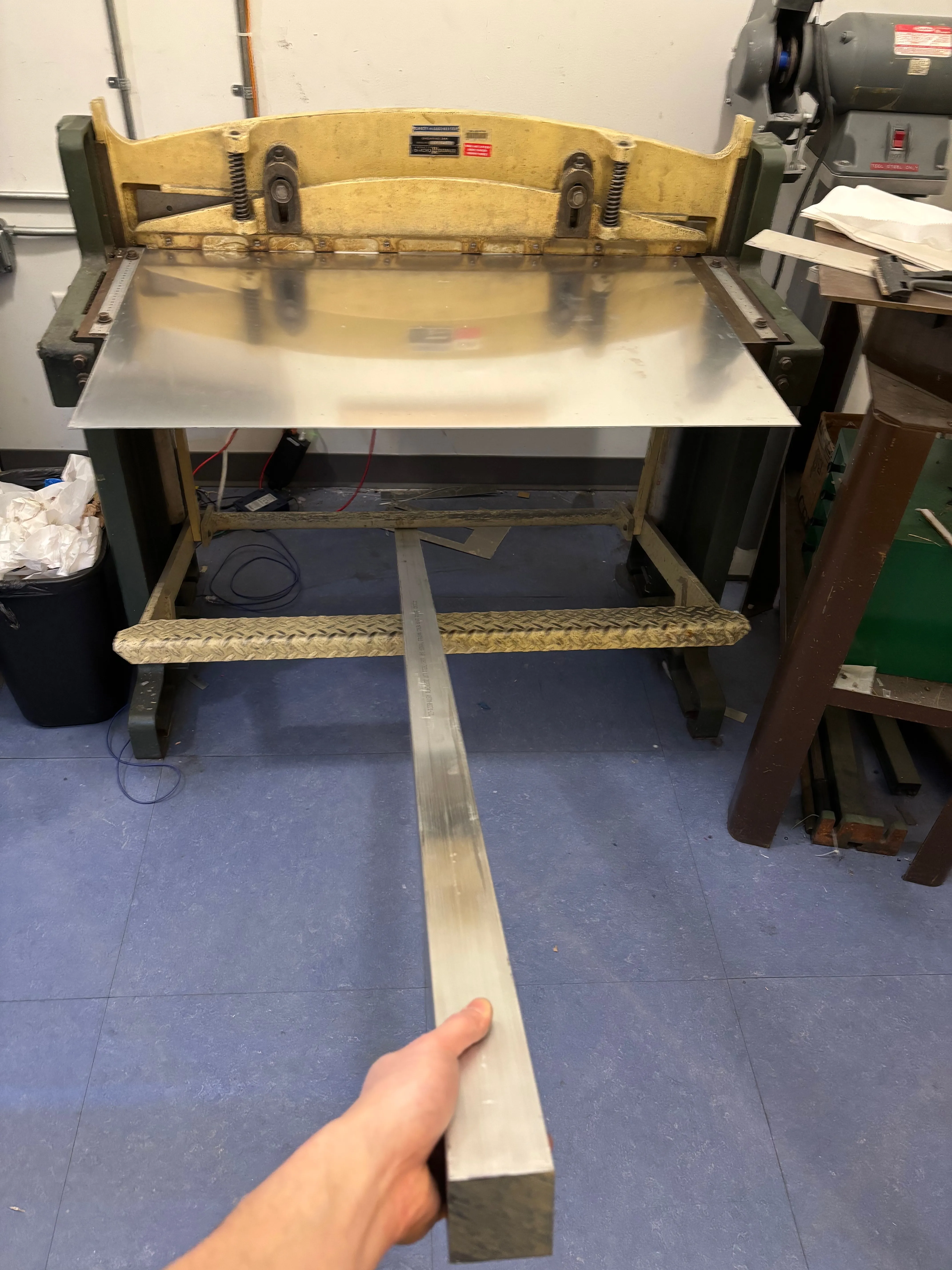 Top of sheet metal tissue box being filed as it is held in a vice