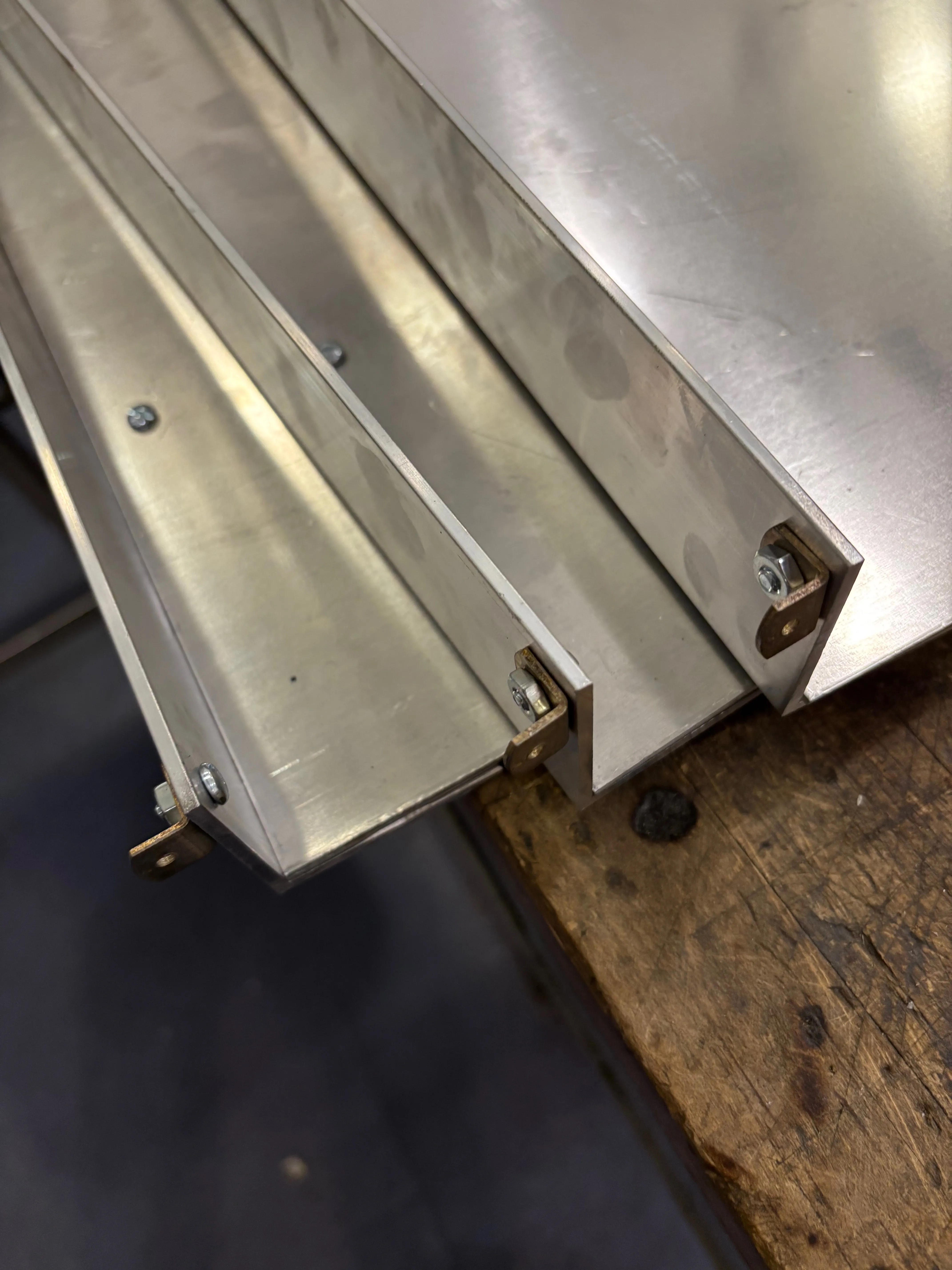 Angle brackets that connect the lip of each shelf to the front legs