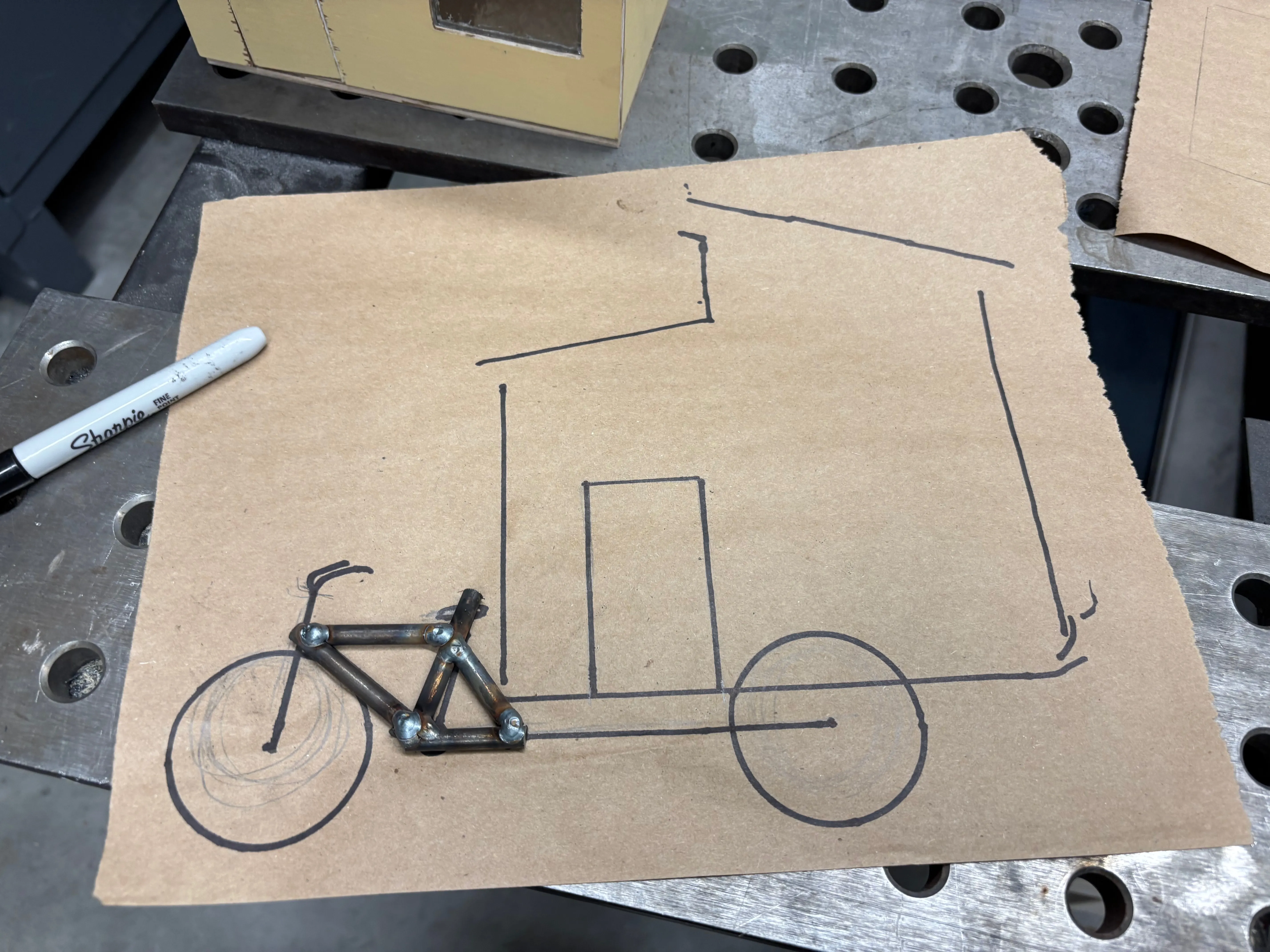 Welded diamond frame of the bike placed on the sketch.